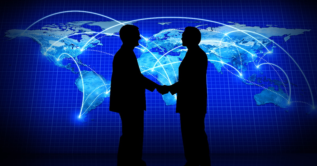 This picture is of two business people shaking hands in front of a backdrop of a world map. The picture indicates the professional nature of a Risk Defense during a custom safety audit.